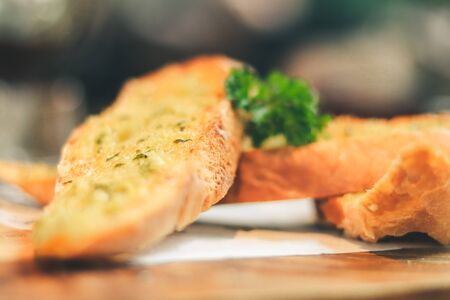 Close up Freshly baked garlic bread on wood plate.の写真素材