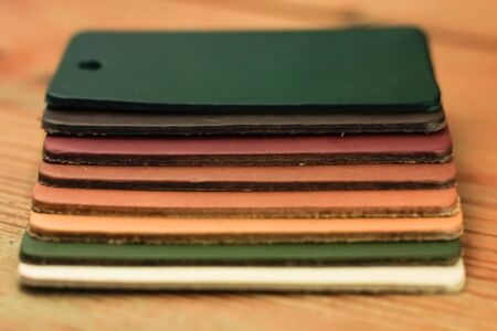 Natural leather samples variety shades of colors on wood table