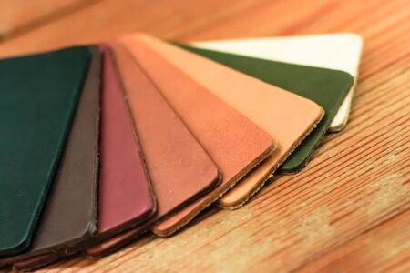 Natural leather samples variety shades of colors on wood table