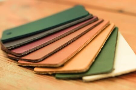 Natural leather samples variety shades of colors on wood tableの写真素材
