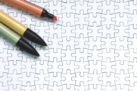 Colorful marker pen on white jigsaw puzzle background.の写真素材