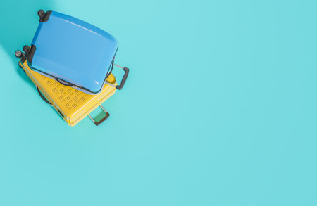 Flat lay yellow and blue suitcase on light blue background. Summer travel concept.,3d model and illustration.の写真素材