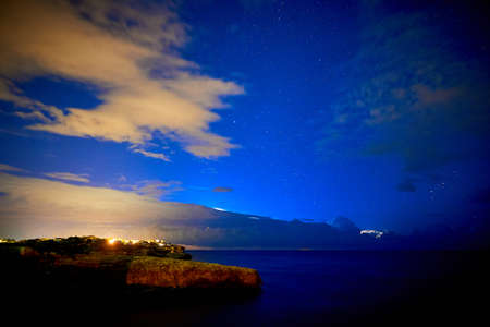 Beautiful starry sky with a thunderstorm in the sea in the background