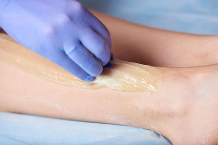 Hair removal method sugaring on legs in a beauty salonの写真素材