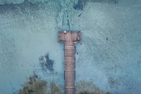Aerial view of a wooden pier on a frozen lake in winter