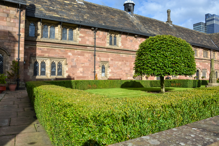 A nice square with trees and hedges next to Chetham's library in Manchester on a sunny dayのeditorial素材