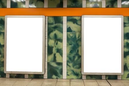 Two blank ad space signs on a wall in the underground from the frontの写真素材