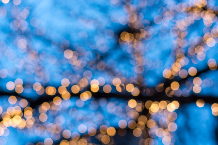Blurred Christmas tree lights outside with blue sky