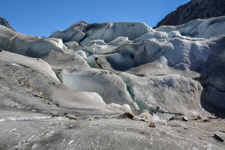 Walking on the Aletsch glacier in Switzerland with its ice hills on a sunny dayの写真素材