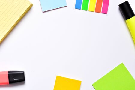 A frame of a desk with post its and a markers on white background
