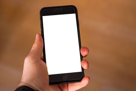 Holding a smartphone with white screen blank ad space close up