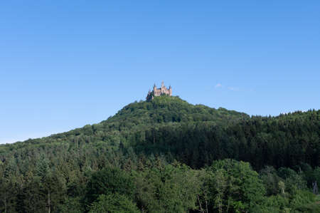 Hohenzollern castle nesting on a hill with lots of trees on a sunny dayのeditorial素材