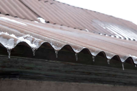 The roof of the building. Icicles on the roof. Winter photosの写真素材