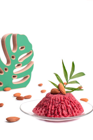 Aquafaba ice cream. Healthy sweets. Proper nutrition. A cake with fruit on top of a table.Monstera leaf decor on backgroundの写真素材