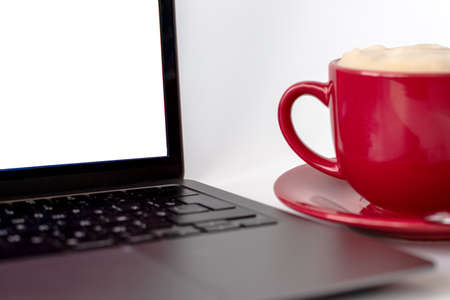 A cup of coffee and a laptop computer are on the table. Selective focusの写真素材