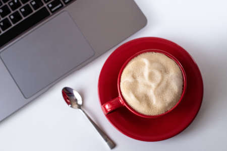 Flat Lay office desk. Red cup with coffee top view.Work from home. desk office with laptop and coffee cup on a white table. Flat lay top view copy space.の写真素材