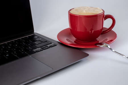 A cup of coffee and a laptop computer are on the table. Selective focusの写真素材