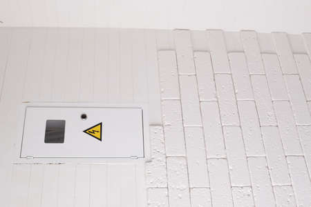 Box for electrical machines and a meter. The brickwork on the wall is white. Electricityの写真素材