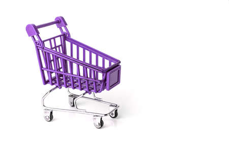 Close up of supermarket grocery push cart for shopping with black wheels and plastic elements on handle isolated on white background. Concept of shopping. Copy space for advertisementの写真素材