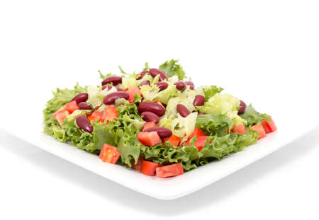 Salad, tomato, beans lie on a plate on a white background.の写真素材