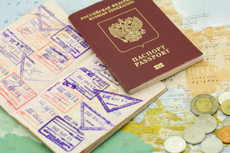 Passports with stamps and coins lie on the shown cardの写真素材