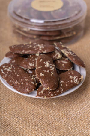 Chocolate chip cookies in a white plate on a burlap background