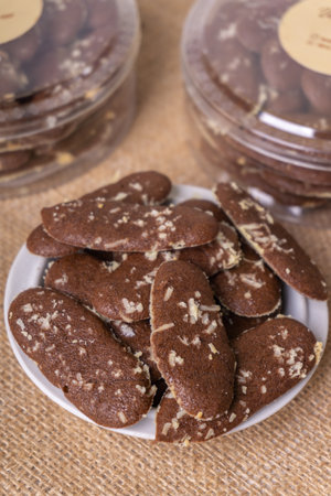 Chocolate chip cookies in a glass jar on jute background.の写真素材