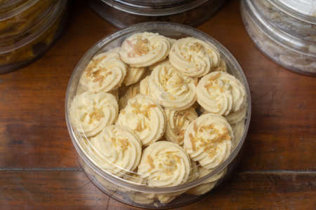 Coconut cookies in a glass bowl on a wooden table.の写真素材