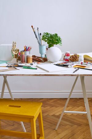 Artist studio with paper and utensils. Workspace of designer illustrator with lots of materilals and...