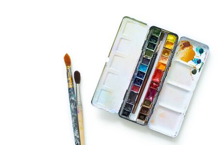Set of watercolor paints and brushes often used by professional artist. Realistic image with spots, blots and traces of use. Isolated on white backgroundの写真素材