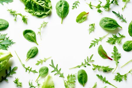 Colourful salad flat design on white background with copy space. Romaine, arugula, spinach and mizuna leaves flatlay. Vegan meal ingredientsの写真素材