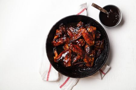Chicken wings with sauce on white background with red striped towel. Summer barbeque concept.の写真素材