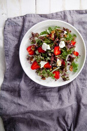 Plate of strawberry salad with balsamic vinegar, fennel, cream cheese, walnuts and greens on gray linen napkin. Easy summer food concept. の写真素材