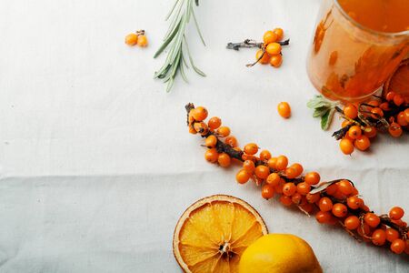 Warm sweet organic tea with sea buckthorn berries, thyme and honey. White background, natural...