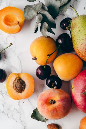 Summer fruits assorted on white marble background. Fresh raw food concept. Close upの写真素材