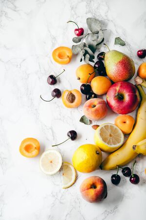 Summer fruits assorted on white marble background. Fresh raw food concept. Copy spaceの写真素材