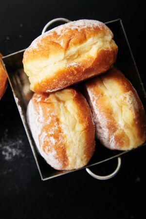 Closeup image of sufganiyot donuts with jelly on black background