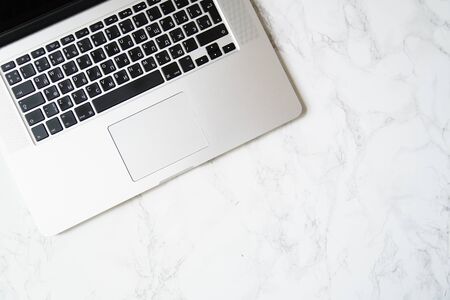 Overhead image of working space with laptop on marble table