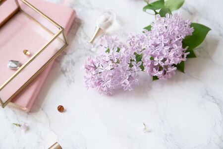Top vew composition with feminine workspace mock up with lilac flowers and pink accessories on marble backgroundの写真素材