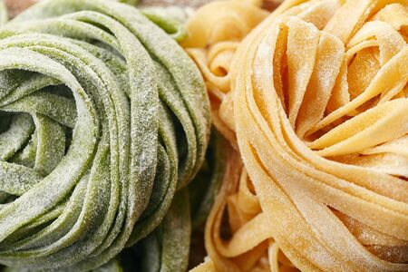 Two types of handmade italian tagliatelle pasta: classical one and green one with spinachの写真素材