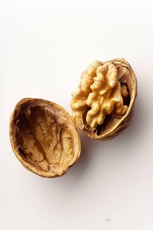 Raw walnuts with cracked nutshells on white background isolated with copy spaceの写真素材
