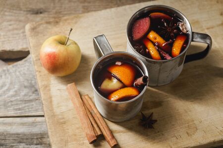 Mulled wine with apple, orange, cardamom, cinnamon, anise and honey. Served in metallic mugs. Wintertime mood.の写真素材