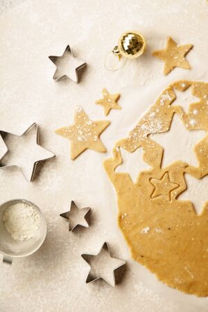 Cooking swedish ginger cookies in a star shape, cutting. Flatlay, overhead composition. Christmas...