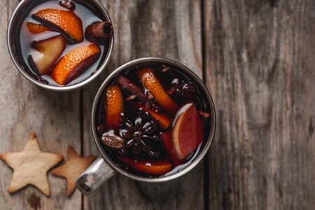 Mulled wine with apple, orange, cardamom, cinnamon, anise and honey. Served in metallic mugs. Wintertime mood.の写真素材