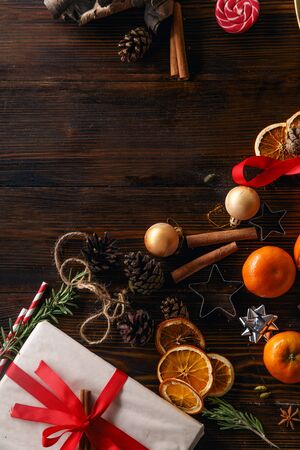 Christmas atmoshpere flatlay. Overhead view. Gingerbread cookies, tangerines and new year decorations on wooden backgroundの写真素材