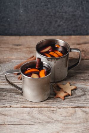 Mulled wine with apple, orange, cardamom, cinnamon, anise and honey. Served in metallic mugs. Wintertime mood.の写真素材