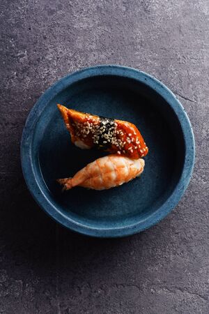 Overhead image of two sushi served on a plate. Shrimp and unagi on concrete backgroundの写真素材