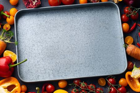 Flatlay with empty metallic tray and colorful vegetables. Frame with copy space at the centre. Creative layout, view from aboveの写真素材