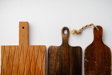 Various wooden tableware. Cutting boards on white background with copy space