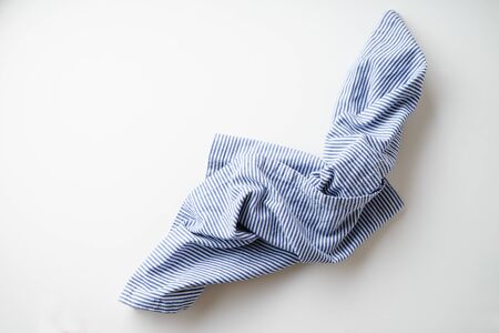 Striped blue and white textile napkin folded on white background. Food styling elementの写真素材